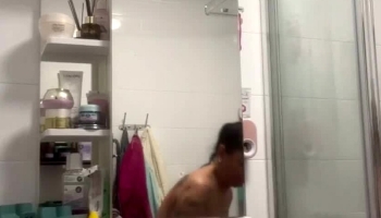 Tanned girl with big fake boobs in shower